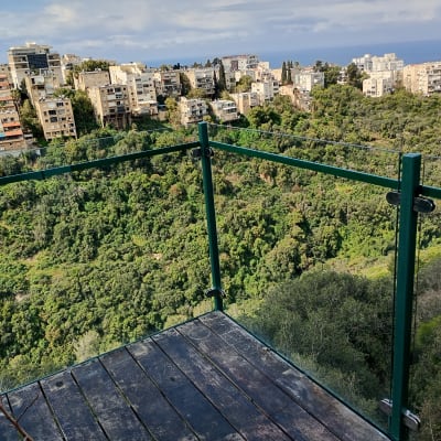 מעקה זכוכית עם נוף לעיר ולים ברקע