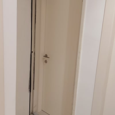 דלת לבנה עם ידית מתכת, קיר לבן