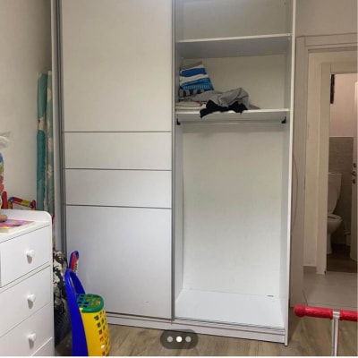 ארון בגדים לבן עם מדפים ובגדים מקופלים