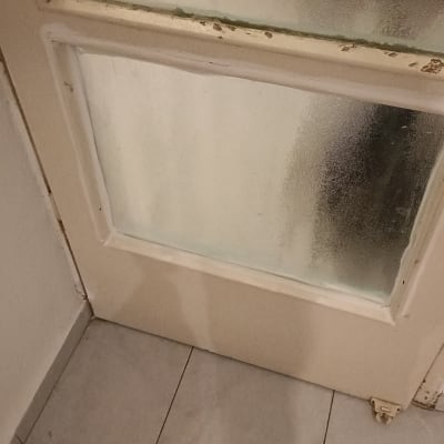 דלת עם זכוכית מטושטשת במסגרת עץ