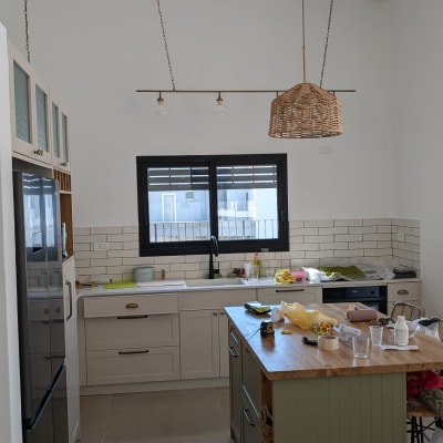 מטבח עם תאורה תלויה וכלים על השיש