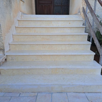 מדרגות שיש חיצוניות עם מעקה עץ בצד ימין