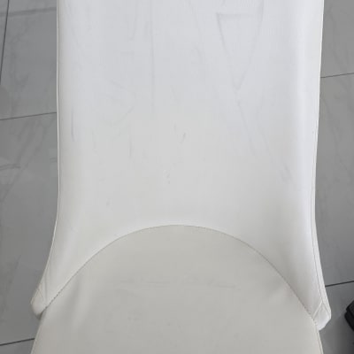 כיסא מרופד בלבן על רצפת אריחים אפורה