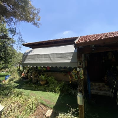 סוכך אפור גדול תלוי מעל גינה ירוקה