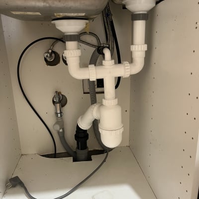 צנרת פלסטיק מתחת לכיור עם חיבורים ואביזרים