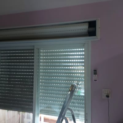 תריסים סגורים עם שלט על קיר ורוד