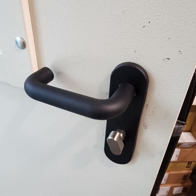 ידית דלת שחורה על דלת לבנה