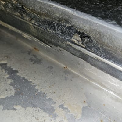 נזילה בקצה משטח מתכת עם סימני חלודה