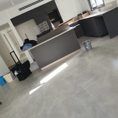 דלי אפור על רצפה, מוצרי ניקוי על שולחן