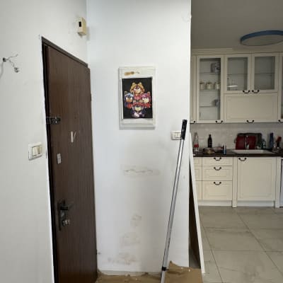 קיר צבוע עם גליל צבע ודלי צבע