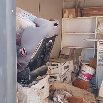 מחסן עם חפצים ישנים, כיסא בטיחות, קופסאות וקרשים