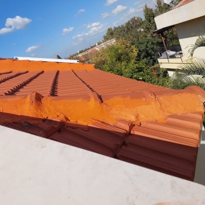גג רעפים כתום עם תיקוני טיח כתומים