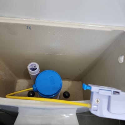 מיכל הדחה עם מכסה כחול וצינור צהוב