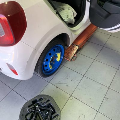 רכב עם גלגל כחול וכלי עבודה על הרצפה