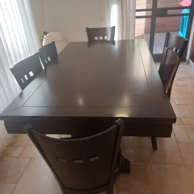 שולחן עץ כהה עם ארבעה כיסאות סביבו