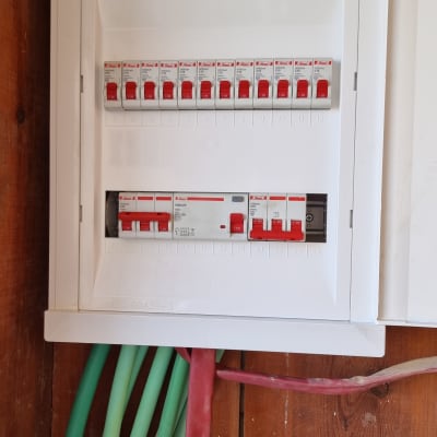 לוח חשמל עם מפסקים וחוטים ירוקים ואדומים