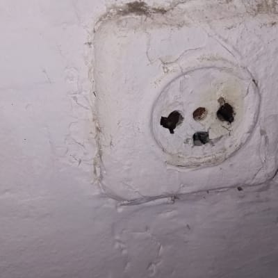 שקע חשמל ישן בקיר מתקלף