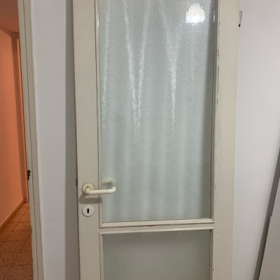 דלת עם זכוכית חלבית במרכז ובחלק התחתון