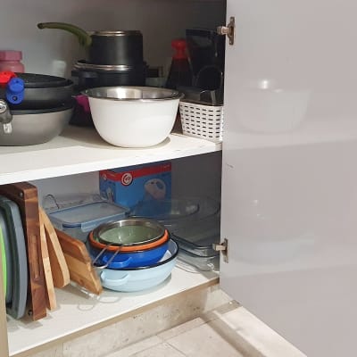 ארון מטבח פתוח עם סירים, קערות ומגשים מסודרים