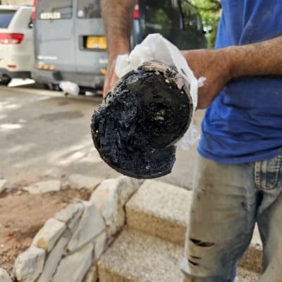 אדם מחזיק צינור סתום עם לכלוך שחור