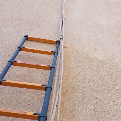 סולם צמוד לקיר עם צינורות חיצוניים