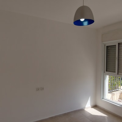 קיר לבן צבוע בחדר עם חלון ותאורה