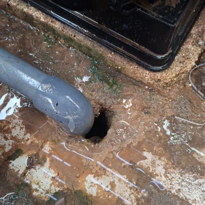 צינור ונזילה על רצפה רטובה עם חור