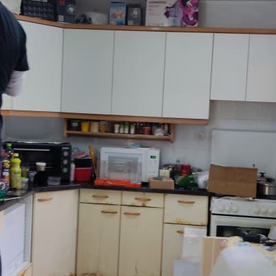 מטבח עם ארונות לבנים, מיקרוגל ותנור אפייה