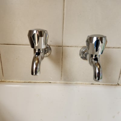 שני ברזים כרומיים מעל כיור לבן