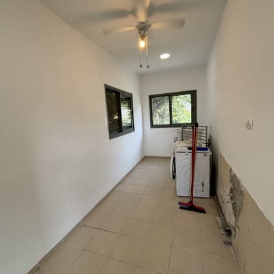 חדר צבוע עם מכונת כביסה ומטאטא
