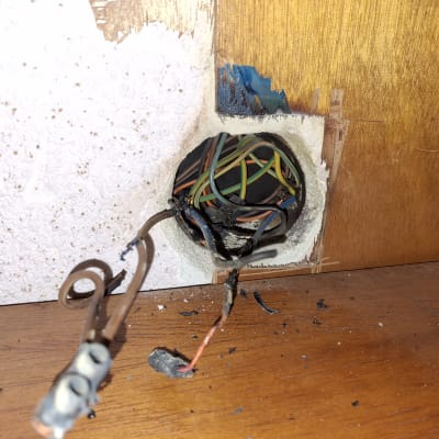 חוטי חשמל חשופים יוצאים מקיר עץ