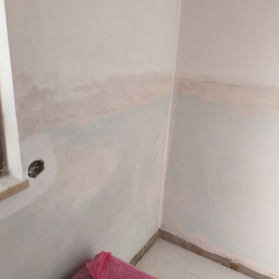 קיר צבוע חלקית עם כיסוי מגן על הרצפה