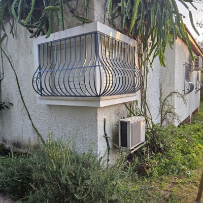 מסגרת מתכת מעוגלת סביב חלון על קיר חיצוני