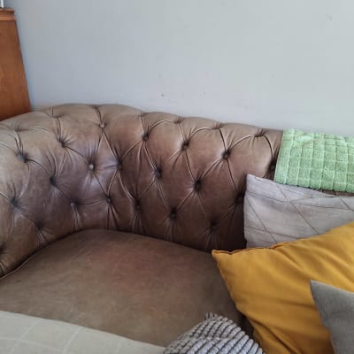 כריות על ספה חומה עם מגבת ירוקה