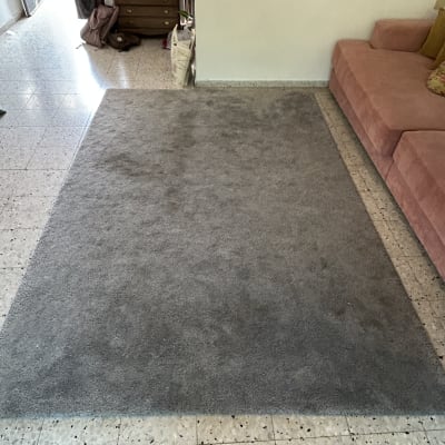 שטיח אפור נקי ליד ספה ורודה בחדר מגורים