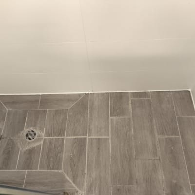 רצפת מקלחת עם ריצוף עץ וניקוז מתכת עגול