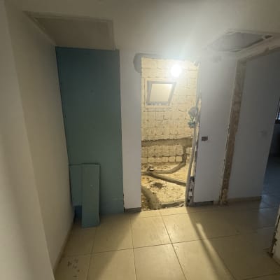 חדר בשיפוץ עם קיר פתוח וצינורות חשופים