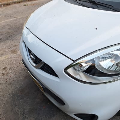 חזית רכב לבן עם פנס קדמי ומכסה מנוע