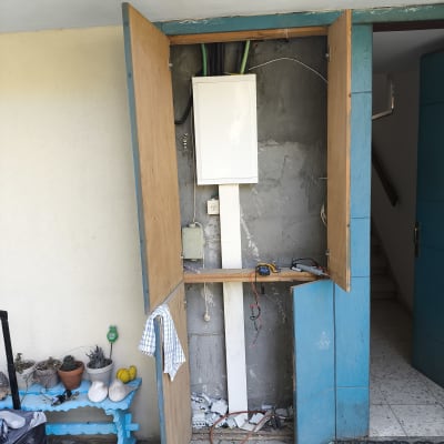 ארון חשמל פתוח עם חוטים וכלי עבודה