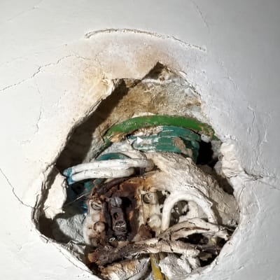 חוטי חשמל ומהדקים שרופים בקיר כתוצאה מקצר חשמלי