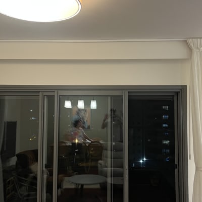 סולם מתכת ליד חלון עם וילונות לבנים