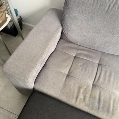 ספה אפורה עם כרית על רצפה אפורה