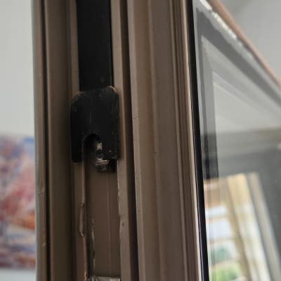 חלק ממסגרת חלון עם תריסים ברקע