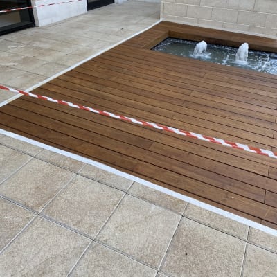 דק עץ ליד מזרקה קטנה עם מים זורמים