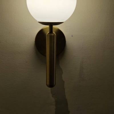 מנורת קיר עגולה ושקע חשמל על הקיר