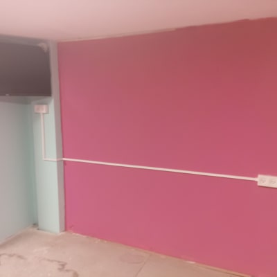 שקעי חשמל על קיר ורוד עם חוטים גלויים