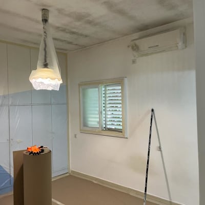 חדר עם גליל קרטון, מטאטא, וניילון על מנורה