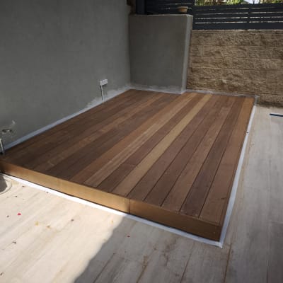 דק עץ מותקן בחצר עם כלים מסביב