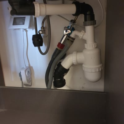 צנרת פלסטיק מתחת לכיור עם מחברים וברזים