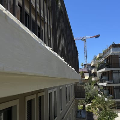 מרפסת עם מעקה, בניין, מנוף ברקע